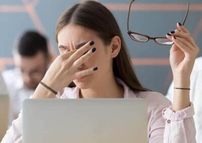 Person rubbing their eyes after prolonged screen use, representing eye strain.
